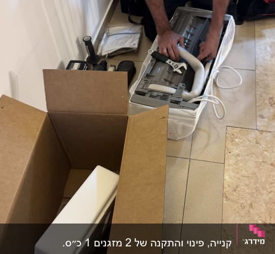 התקנת מזגן עם כלים ואריזות על הרצפה